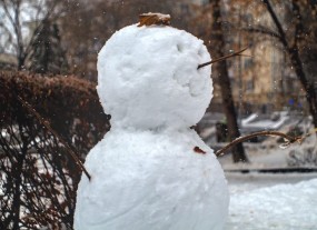 Ein mit Ästen verzierter Schneemann.